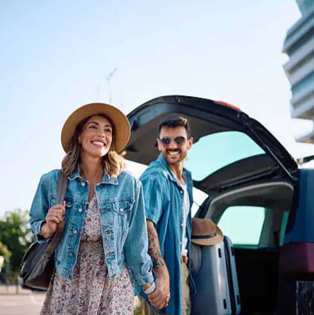 Couple loading luggage into a car, ready to travel