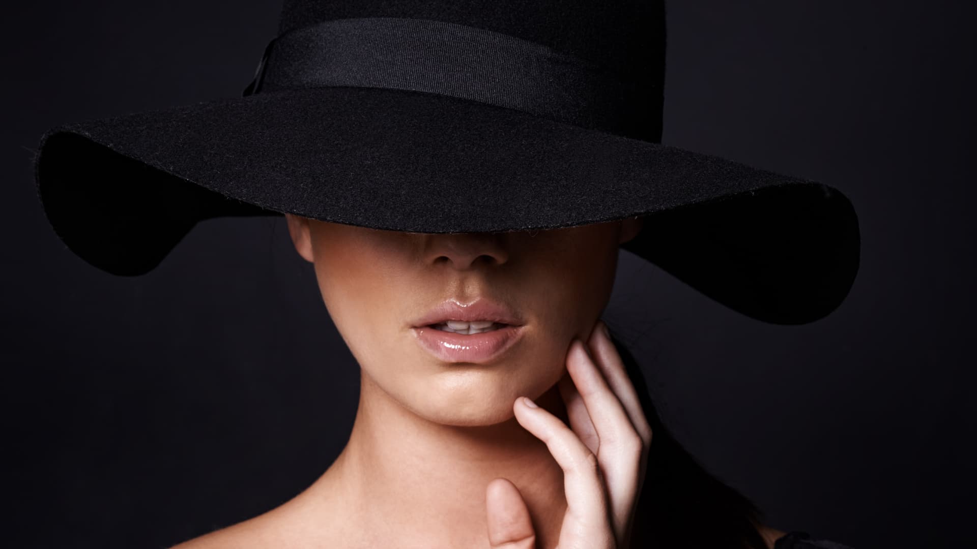 Elegant portrait of a woman in a wide-brimmed black hat