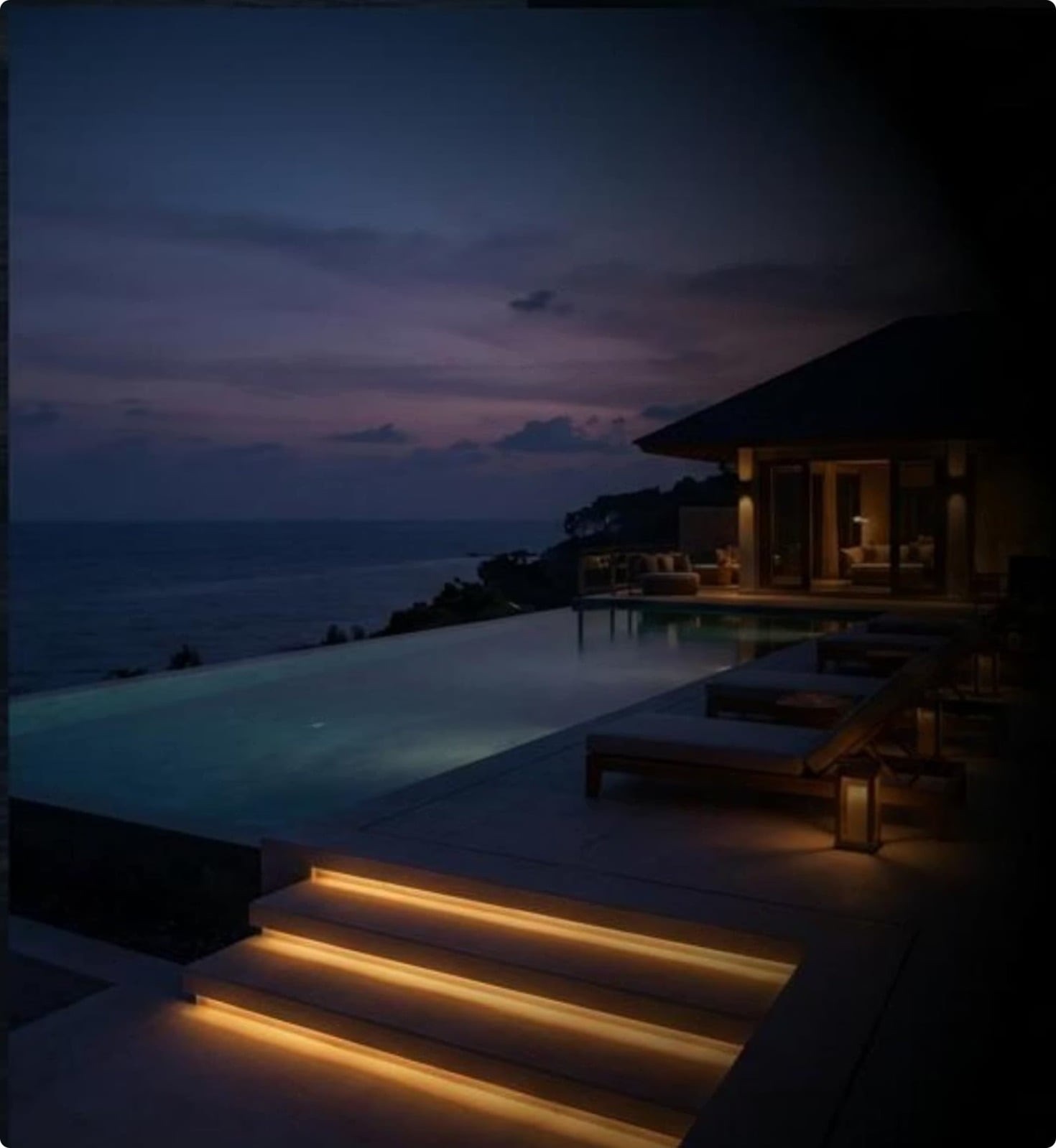 Infinity pool and villa terrace at dusk